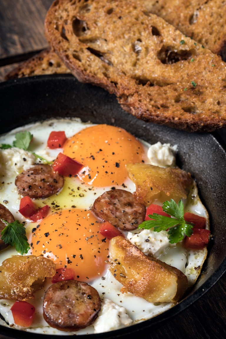 Baked eggs with sausage, feta cheese and peppers