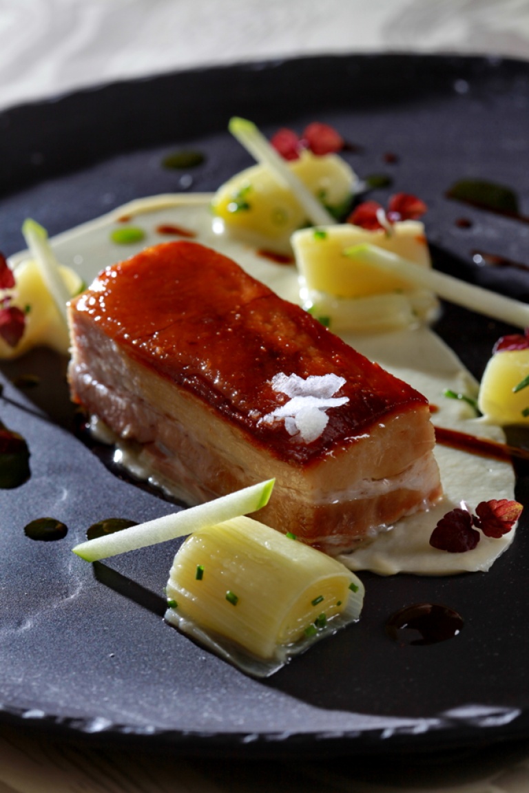 Pork pancetta with braised leek, celeriac puree and coriander sauce